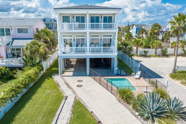 A two-story house with a balcony, a swimming pool, and a well-maintained lawn. - Beachfront Home! Beach Access, Pool, Incredible Views, Two Balconies, Elevator, $300 in Free Tickets (St. Augustine)
