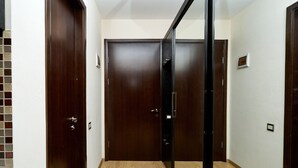 A hallway with wooden doors and a mirrored closet. - MaRKoS Flat in Block 1, New Gudauri (Gudauri)