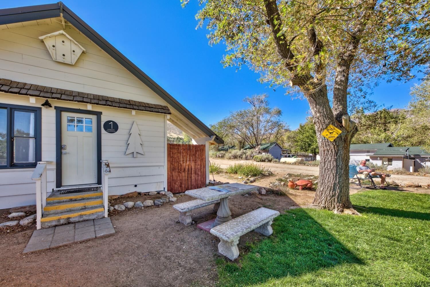 A single-story house with a front porch, a mailbox, and a number '1' sign.