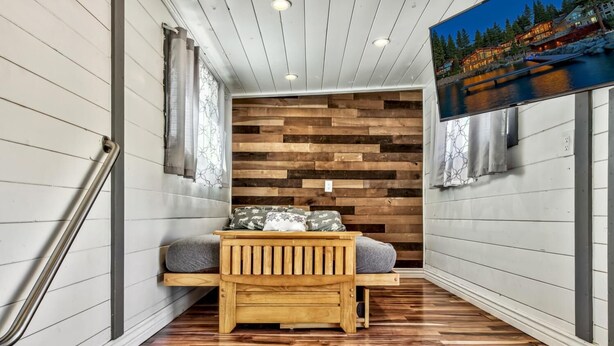 A narrow hallway with a wooden bench and a wooden wall with a herringbone pattern.
