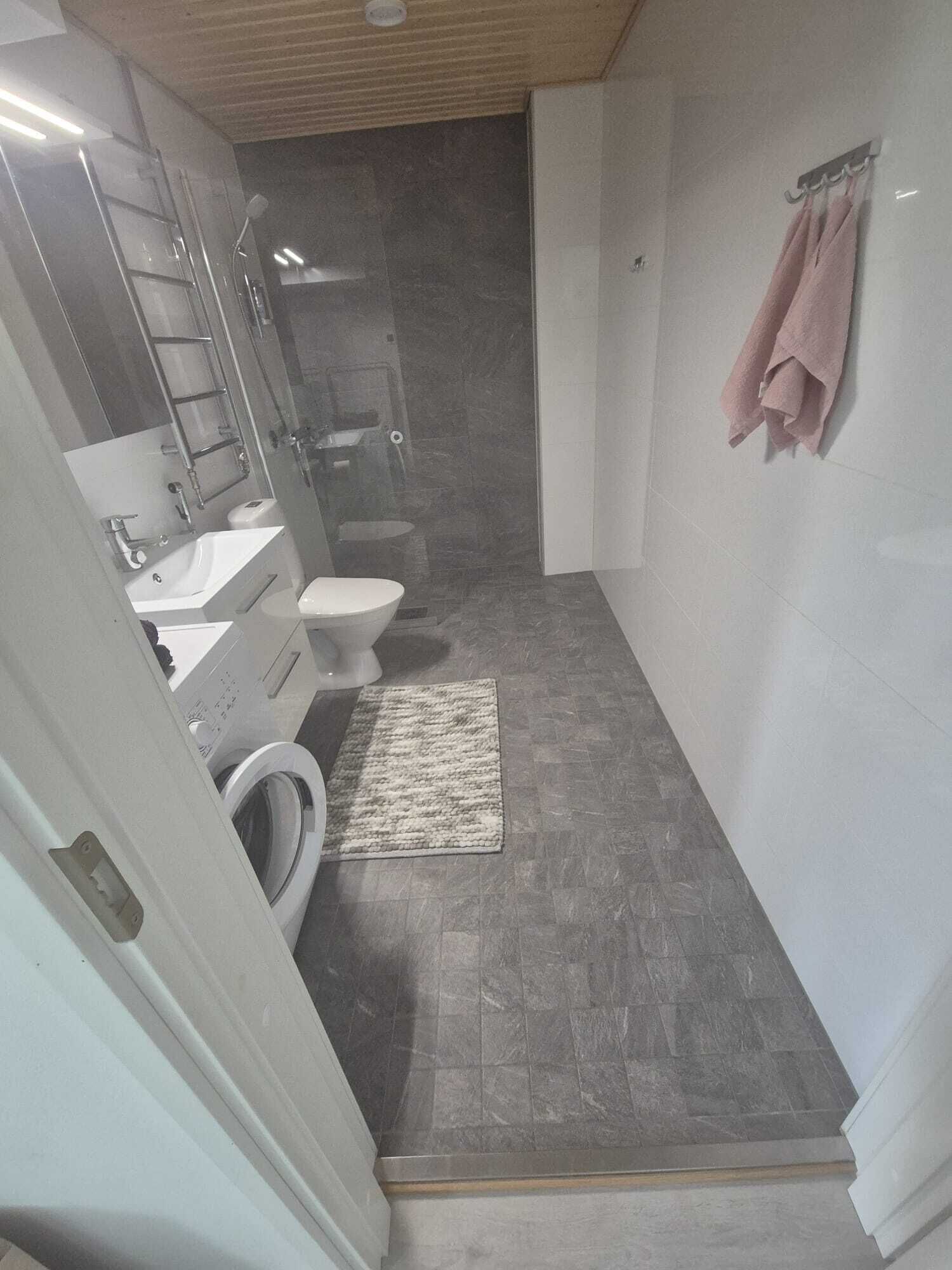Un bagno compatto con servizi igienici, lavabo e lavatrice.