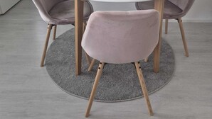 A round white table with four chairs, a small decorative item on the table, and a grey rug on the floor. - Metsämansikan helmi I Free parking, WiFi and Netflix (Espoo)