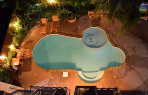 An aerial view of a swimming pool with a unique shape, surrounded by lounge chairs and potted plants. - Double Room | Great for Couples on a Budget (Unknown)