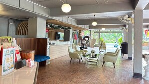 A modern interior with a reception desk, seating area, and large windows. - Elegant Deluxe DBL  Stylish Chiangmai Comfort (Chiang Mai)