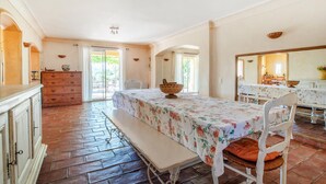 Une pièce spacieuse avec une grande table à manger, un banc et un buffet en bois.
