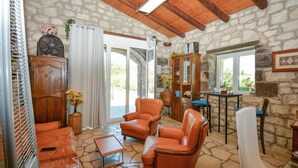 A cozy living room with stone walls, leather furniture, and a wooden ceiling. - Stunning home in Monterosso Almo (Monterosso Almo)