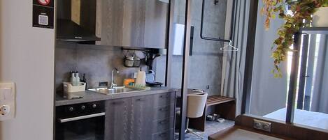 Una cocina moderna con encimera de granito, horno empotrado y comedor con una silla y mesa.