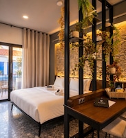 A modern hotel room with a bed, a desk, and a view of the outside.