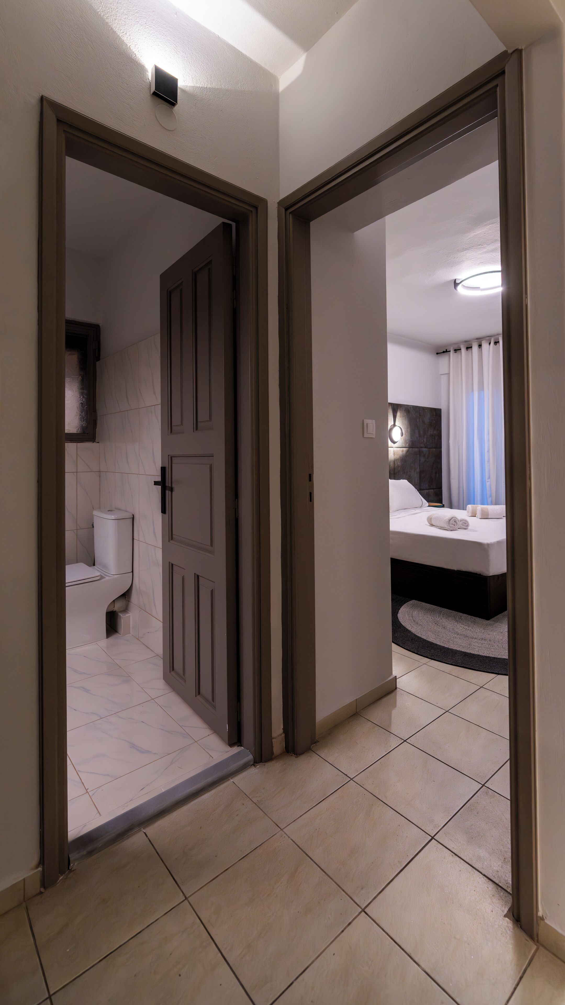 A hotel room with a bathroom and a bedroom.