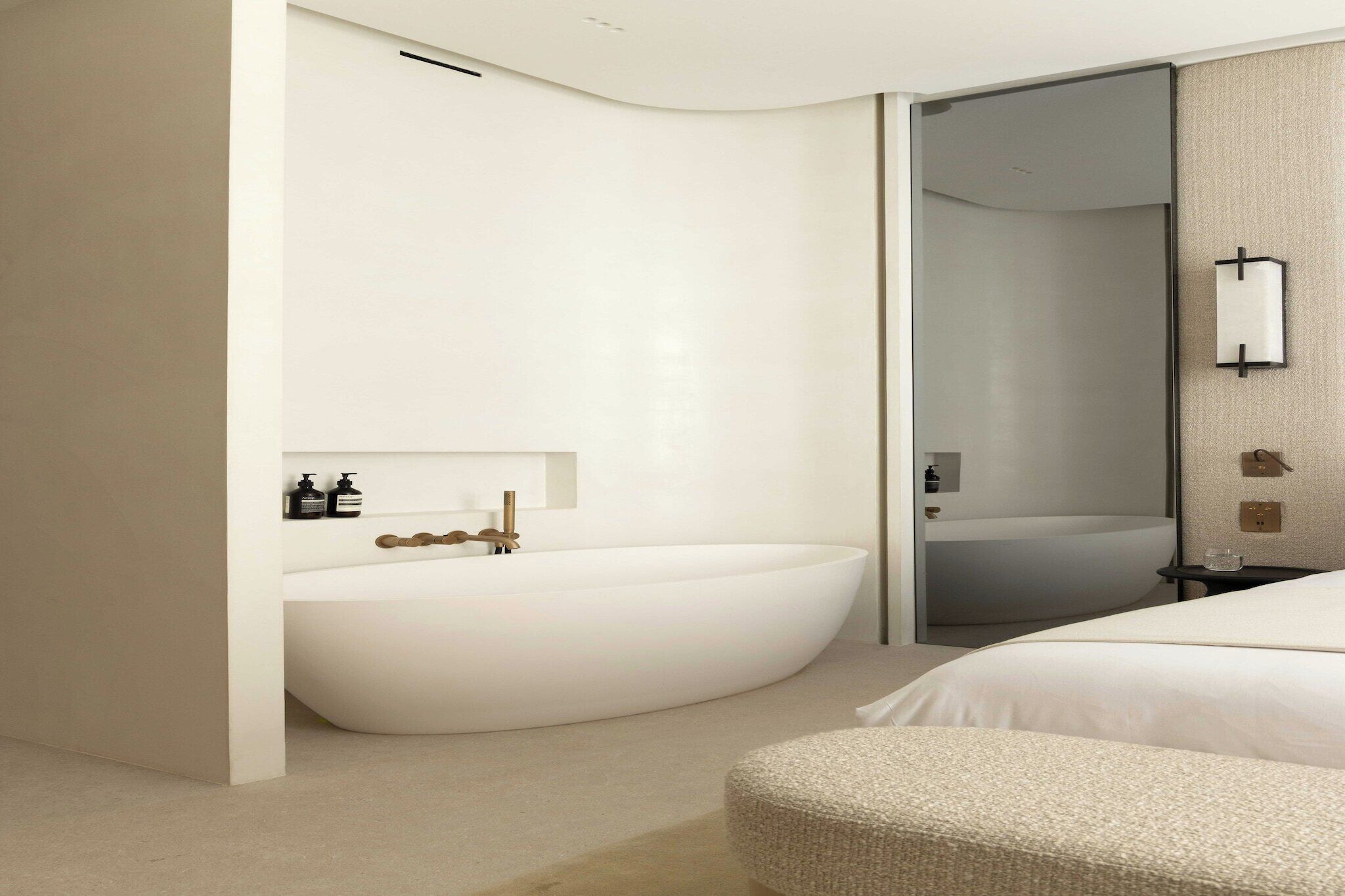 Une salle de bain moderne avec une baignoire sur pieds, une douche à parois de verre et une table de chevet dotée d’une lampe de nuit.