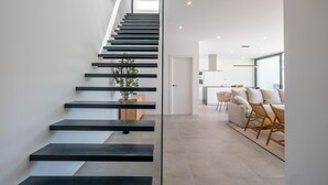 Uma escadaria moderna com degraus pretos e uma planta no patamar.