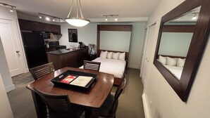 A compact hotel room with a kitchenette, a dining area, and a large bed. - Slope Side Studio Panorama Resort (Panorama)