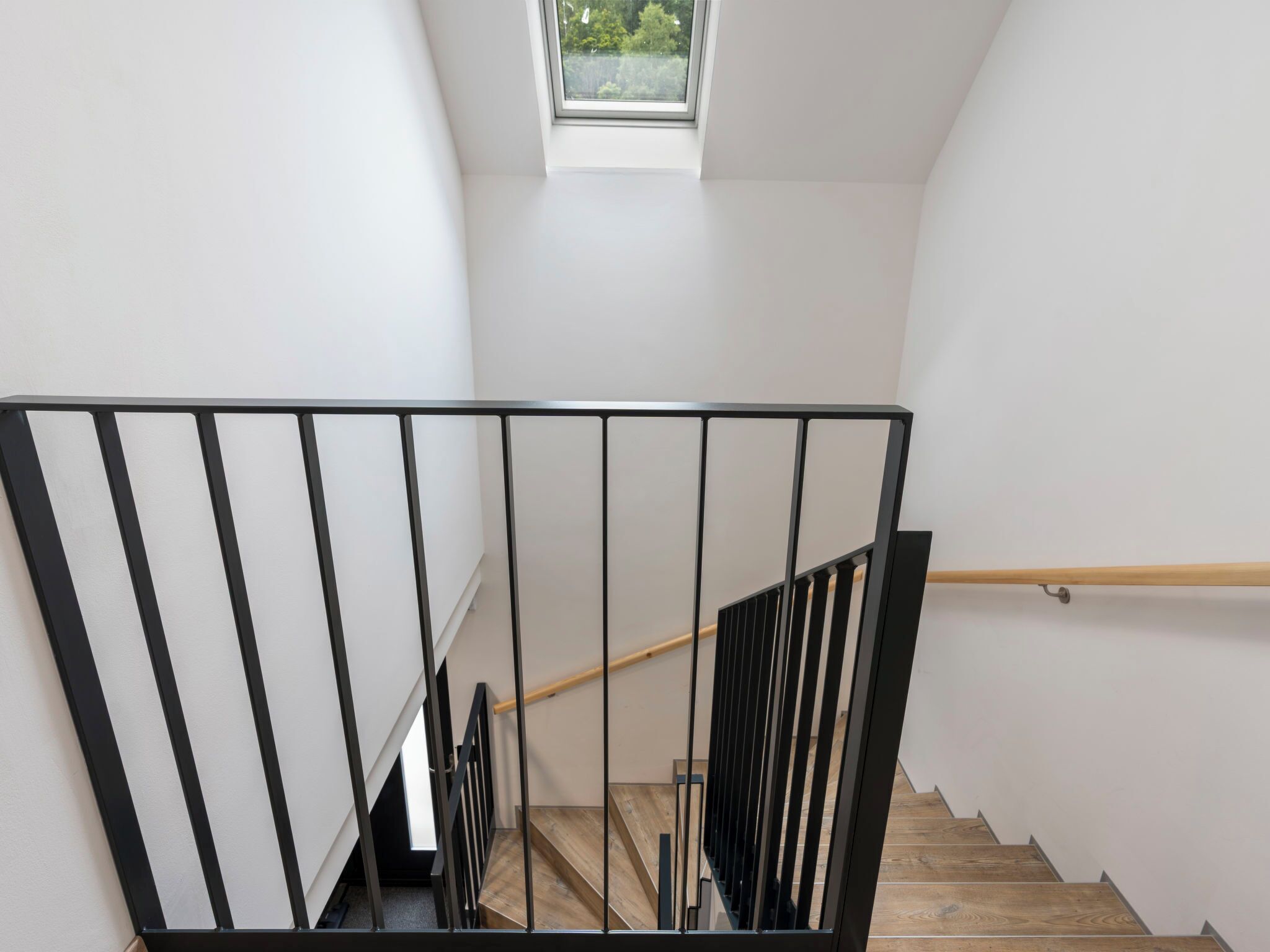 A staircase with black railings and wooden steps.