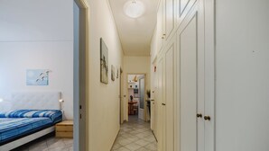 Un couloir étroit, avec un lit à gauche et une armoire à droite.