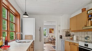 Une cuisine avec des meubles en bois, un évier en acier inoxydable et un dosseret carrelé.