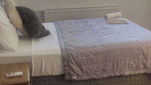A bedroom with a bed, a nightstand, a radiator, and a tiled floor. - 6-bedroom villa in beautiful Ölüdeniz with WiFi, AC (Ölüdeniz)