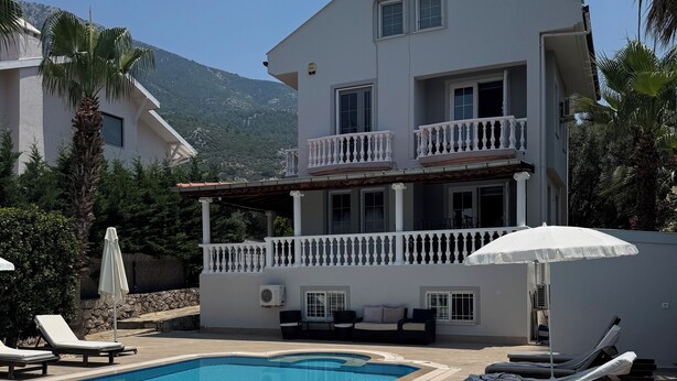 A two-story building with a swimming pool, lounge chairs, and a covered seating area. - 6-bedroom villa in beautiful Ölüdeniz with WiFi, AC (Ölüdeniz)