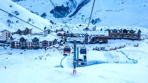 A ski resort with a chairlift, snow-covered buildings, and a mountainous backdrop. - MaRKoS Flat in Block 2, New Gudauri (Gudauri)