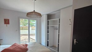 A bedroom with a bed, a wardrobe, and a sliding door to a balcony.