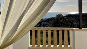 A balcony with a view of the sea and a pergola structure.