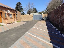 Un estacionamiento con pavimento de ladrillo que conduce a la entrada de un edificio.