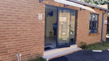 A brick building with a reception area, glass doors, and a sign indicating no firearms or weapons allowed.