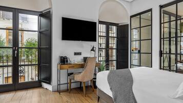 Een slaapkamer met een bed, een bureau en een televisie.
