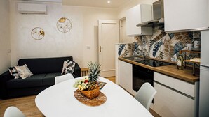 A modern kitchen with a wooden countertop, white cabinets, and a backsplash with tropical leaf patterns. - Principe Genoa Home Train Station Piazza Principe (Unknown)