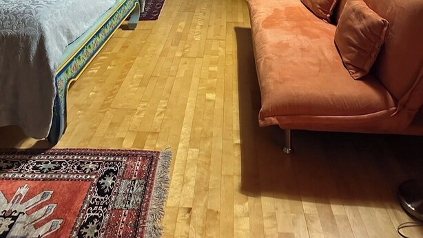 A bedroom with a bed, a sofa, a radiator, and a window. - Ruthellen's Home (Planegg)