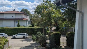 A residential area with a paved driveway, parked cars, and a building with a white exterior. - Ruthellen's Home (Planegg)