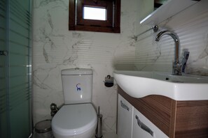 A bathroom with a toilet, sink, and a window above the toilet. -  Palam Pansiyon (Camlihemsin)