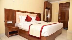 A neatly made bed with a wooden headboard, a bedside table, and a wardrobe.
