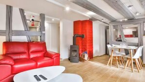 Een moderne woonkamer met een rode leren bank, een witte salontafel en een open haard.