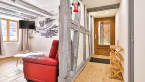 Een moderne woonkamer met een rode bank, een witte salontafel en een houten plank.