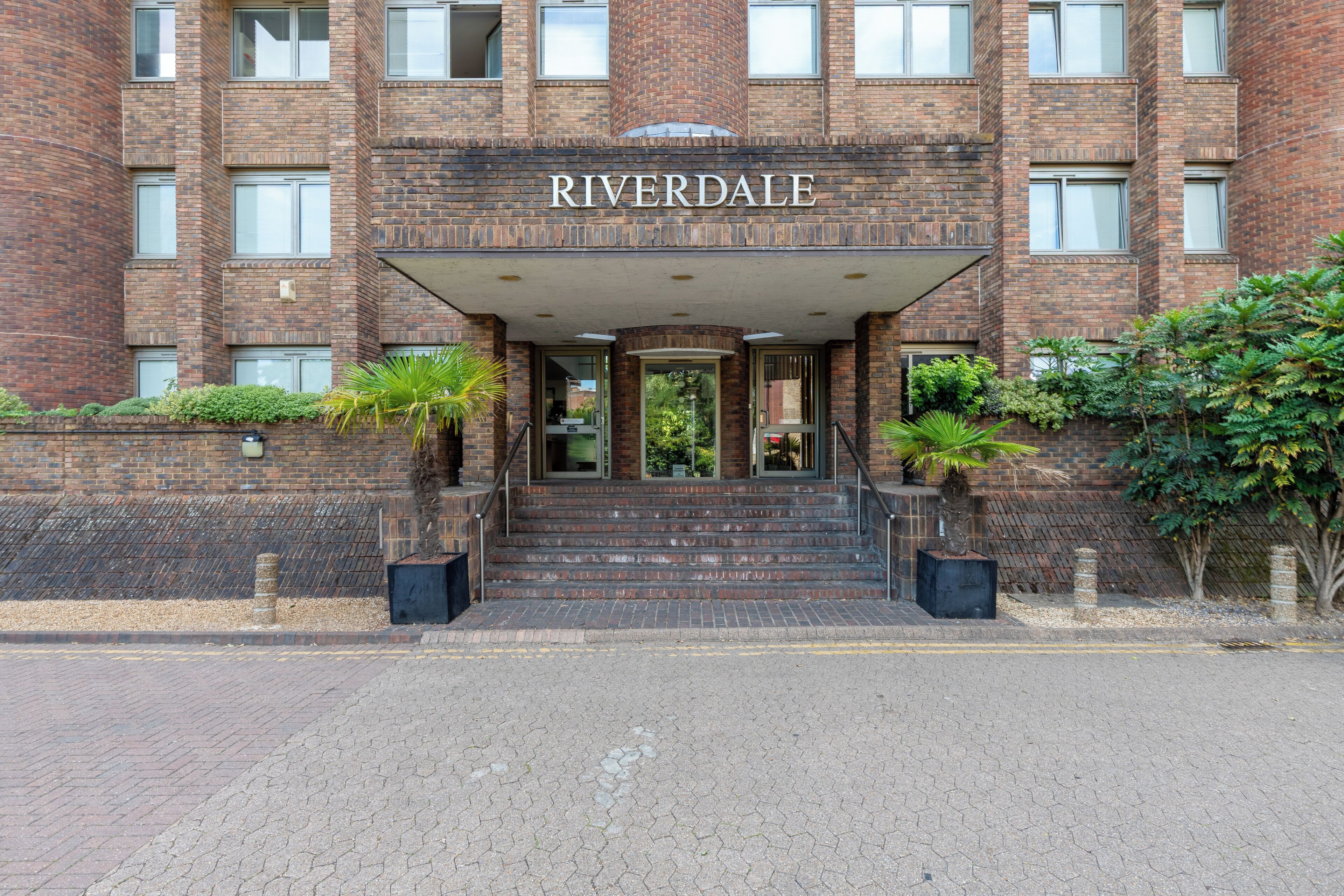 Un edificio de ladrillo con un cartel que dice 'RIVERDALE' sobre la entrada.