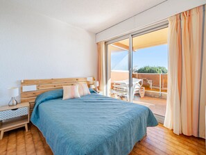 Une chambre à coucher avec une tête de lit en bois, une couvre-lit bleue et une table de chevet avec une lampe.
