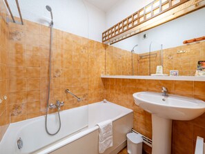 Une salle de bain avec une baignoire, un lavabo et une douche.