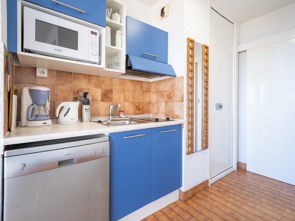 A compact kitchen with a microwave, coffee maker, and dishwasher.