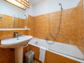 Une salle de bain avec un lavabo, une baignoire et une douche.