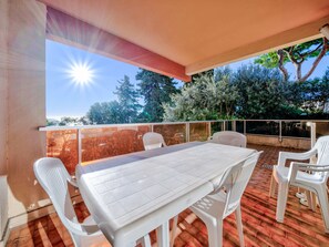 An outdoor patio with a white table and chairs, a red brick floor, and a view of trees and the sky. - Apartment 6 pers, sea view, Wi-Fi, Roquebrune-Cap-Martin (Roquebrune-Cap-Martin)
