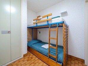 A bunk bed with a wooden frame and blue accents, a white door, and a tiled floor. - Apartment 6 pers, sea view, Wi-Fi, Roquebrune-Cap-Martin (Roquebrune-Cap-Martin)