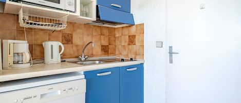 A compact kitchen with a microwave, coffee maker, and dishwasher.
