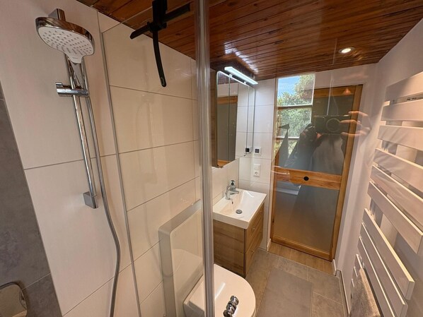 Un baño moderno con ducha, inodoro y lavabo.