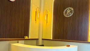 Una recepción con un panel de madera, un reloj y un espejo con un logotipo.