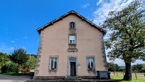 Un bâtiment à deux étages doté d’une façade symétrique, d’une entrée centrale et d’un petit porche.