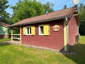 Un bâtiment en bois rouge, avec des volets jaunes et une enseigne portant le nom « Edelweiss ».