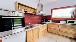 Una cocina moderna con horno Bosch, microondas y armarios de madera.