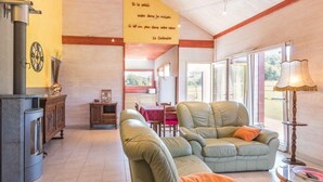 Un salón espacioso con chimenea, comedor y un ventanal con vistas al exterior.