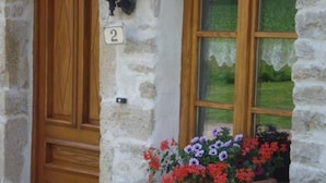 A stone building with a wooden door and a window with a flower box. - Quiet cottage near Villersexel, nature and activities (Esprels)