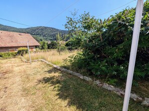 A rural property with a house, a grassy yard, and a hill in the background. - Eco-friendly lodging near Ballon de Servance (Plancher-les-Mines)